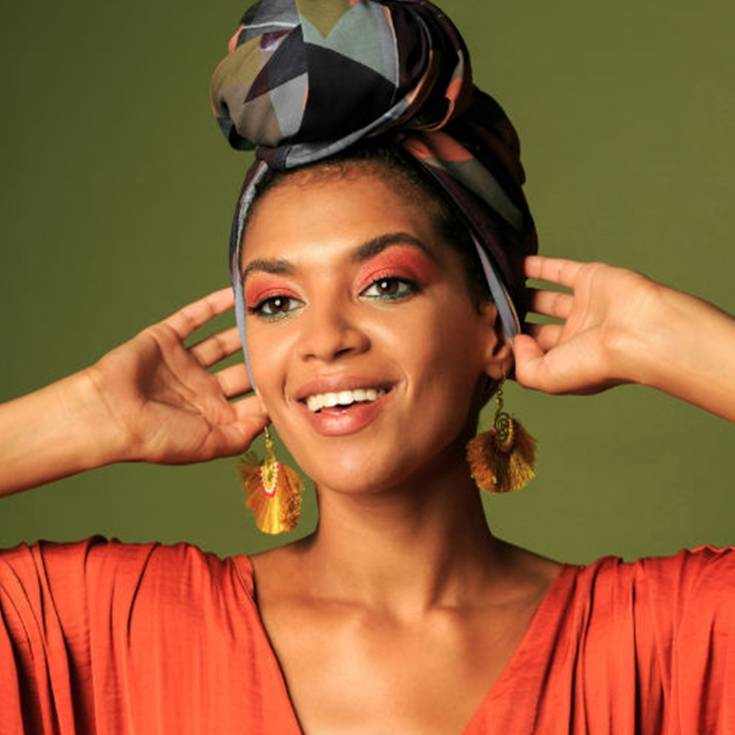 Mulher de etnia negra exibe maquiagem e visual para festa